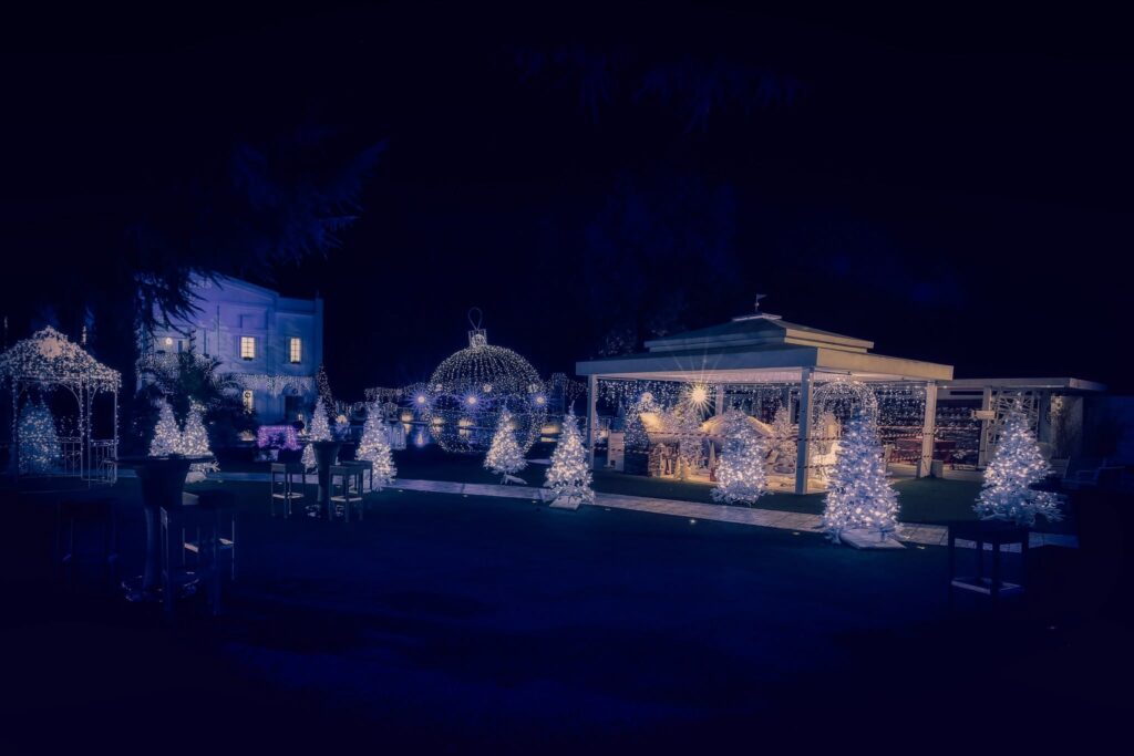 Esterno di Villa ReNoir di notte con gazebo e alberi decorati da luci natalizie